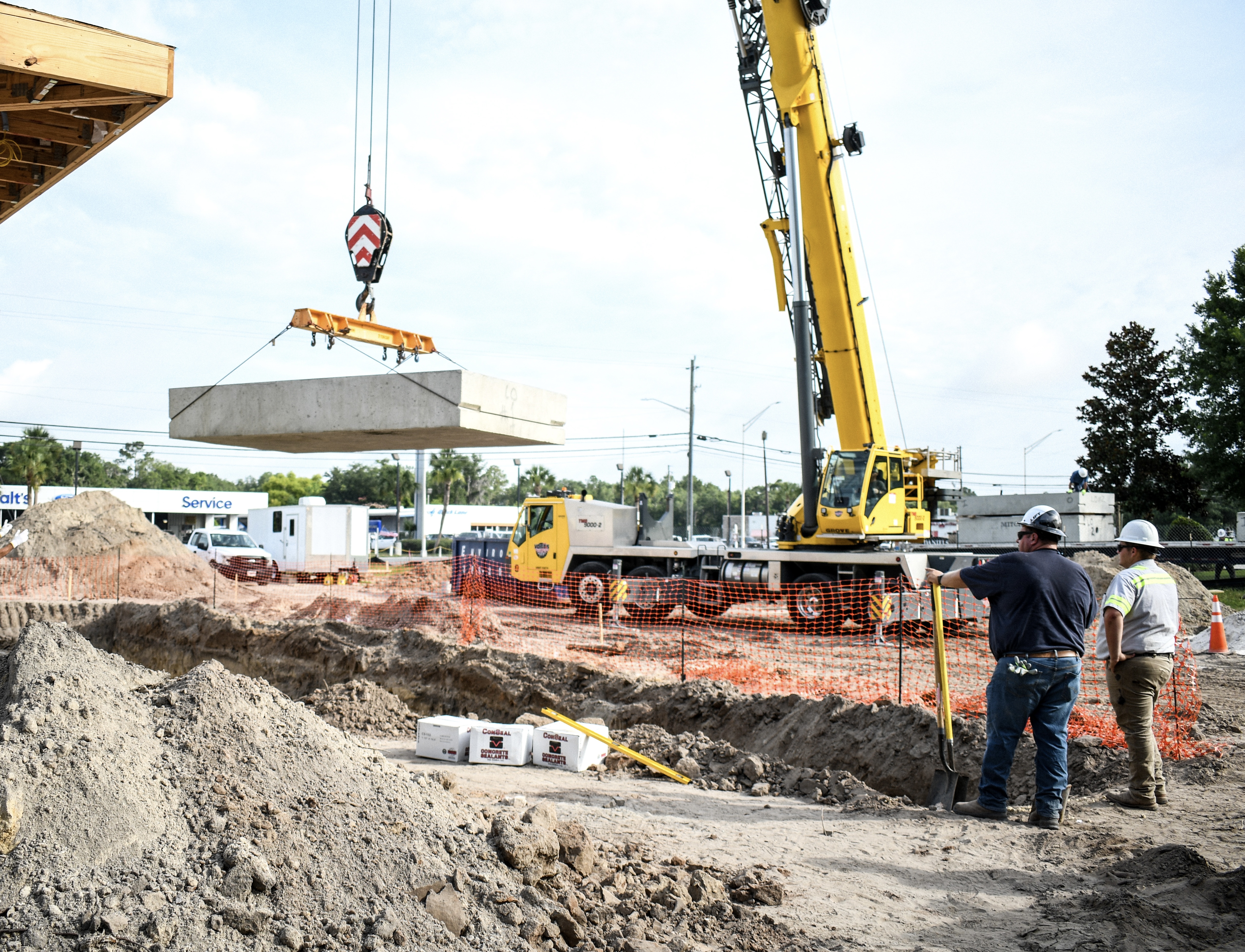 Crane lifting precast concrete panel at commercial site — Lake City FL