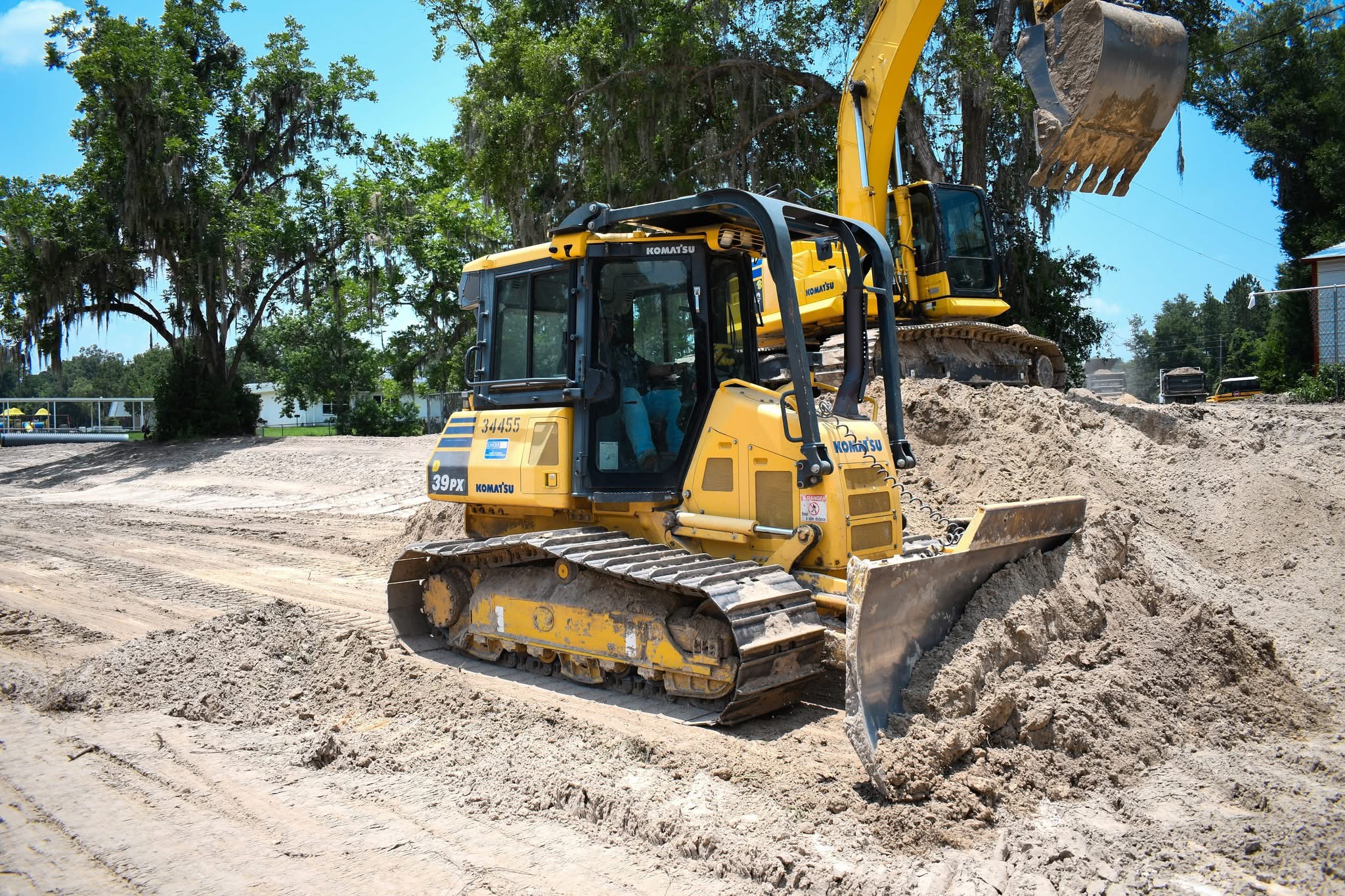 Komatsu dozer and excavator working site grading — Lake City, FL