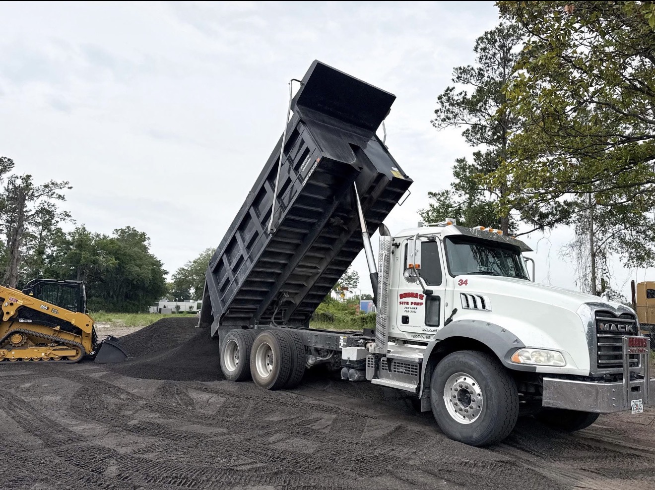 Mack dump truck delivering asphalt material