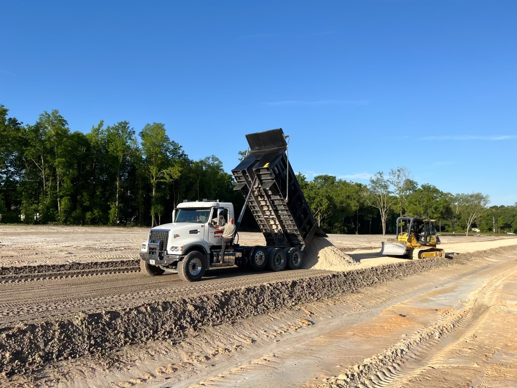 Dump truck unloading fill on site preparation project — Lake City FL