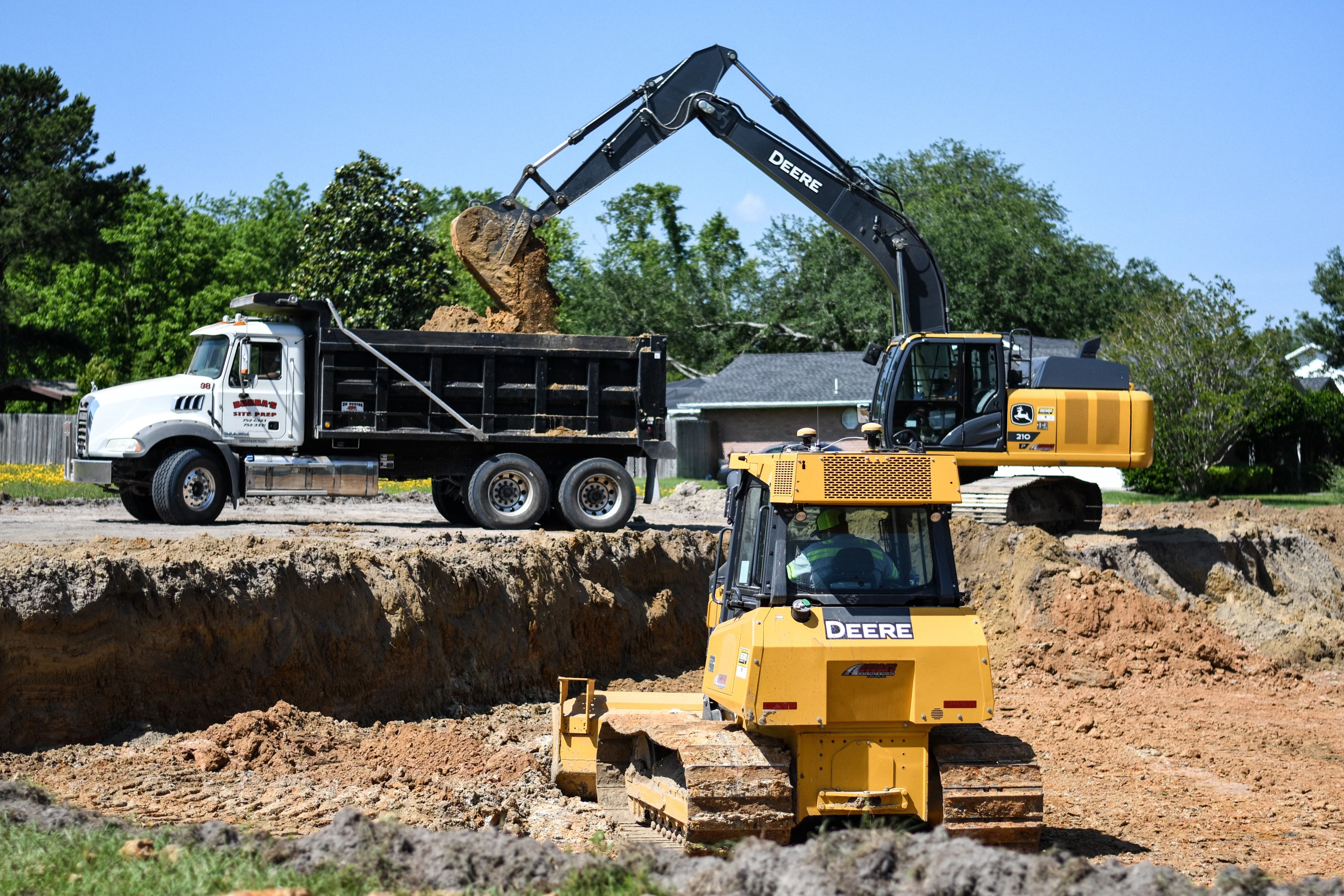 John Deere excavator and dozer working tandem on site prep