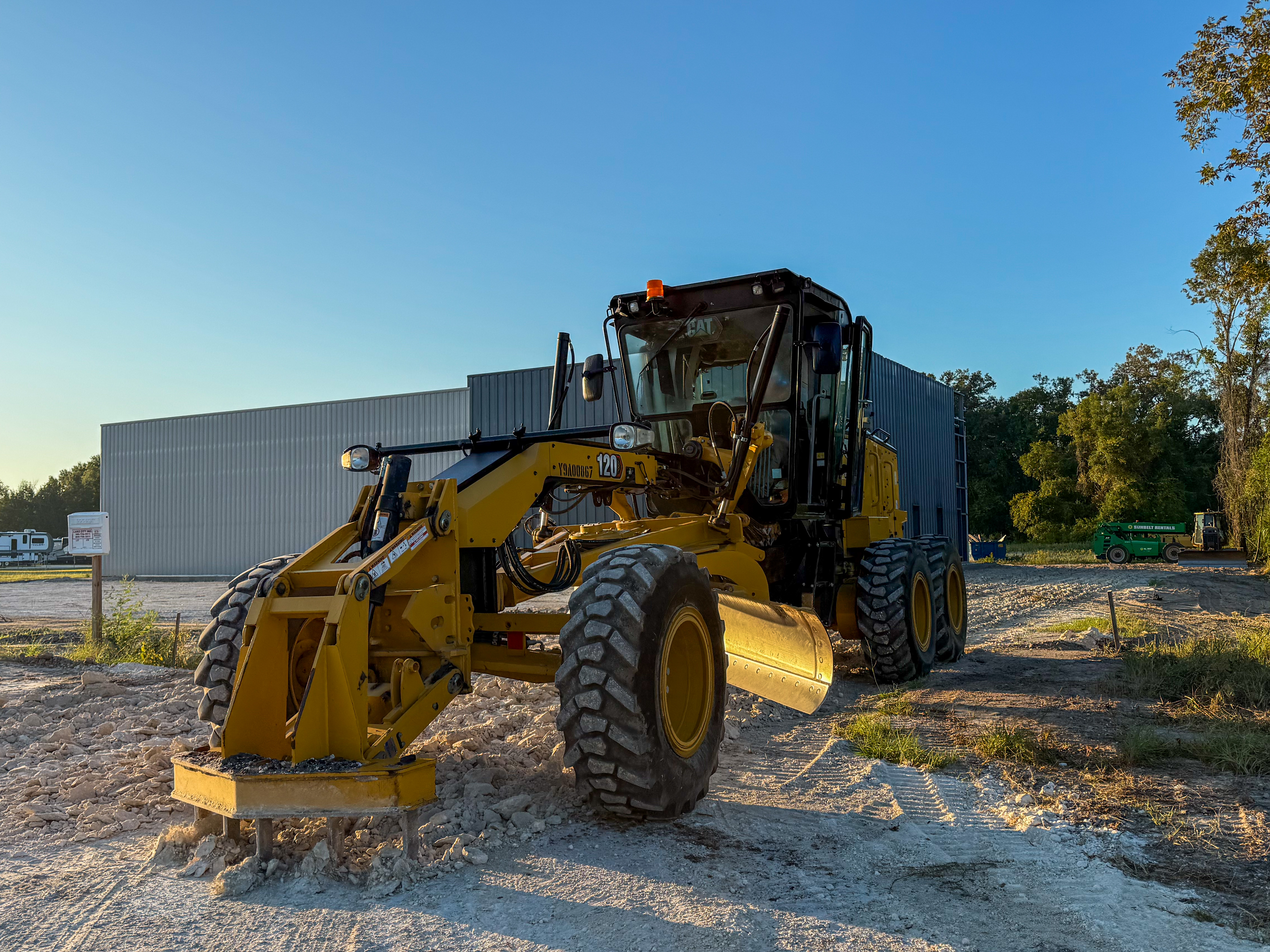 CAT motor grader performing precision grading at dawn — Lake City, FL